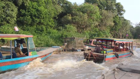 A-motorized-boat-speeds-along-the-Mekong-Delta-river,-ferrying-tourists-to-immerse-themselves-in-the-rich-cultures-of-Kampong-Phluk,-providing-a-unique-cultural-experience