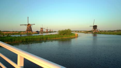 Windmills-lined-up-at-Dutch-historic-mill-destination-Kinderdijk-dolly-in-from-bridge