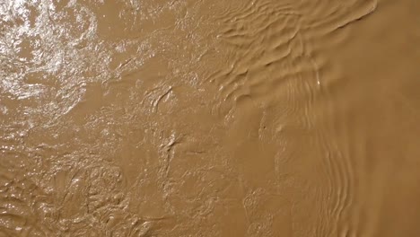 top-view-of-strong-current-of-muddy-and-turbulent-river-flowing-down