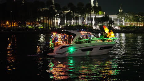People-In-Santa-Costumes-Riding-Boat-With-Christmas-Lights-And-Decorations-At-Night