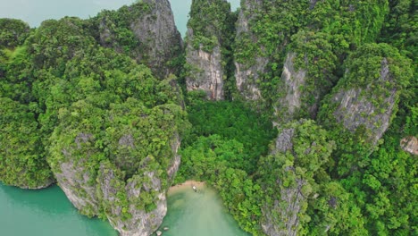 Eine-Luftdrohne-Bietet-Einen-Spektakulären-Blick-Auf-Ein-Longtail-Boot-Inmitten-Türkisfarbenem-Wasser-Und-Kalksteinfelsen-Bei-Blue&#39;s-Hong,-Ko-Roi,-Thailand