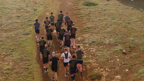 Group-of-mixed-race-White-European-Caucasian-and-Dark-Skinned-Men-wear-trail-running-water-packs-as-they-run-along-dirt-road