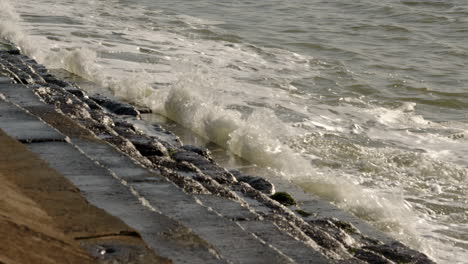 Mittlere-Aufnahme-Von-Wellen,-Die-Gegen-Die-Küstenschutzanlagen-In-Milford-On-Sea-Krachen