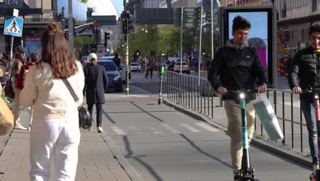 Gente-Caminando,-Andando-En-Bicicleta-Y-Patinetes-En-La-Calle-Estocolmo