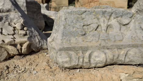 Close-up-of-ancient-Roman-ruins-in-Carthage,-Tunisia,-with-detailed-stone-carvings-and-clear-skies