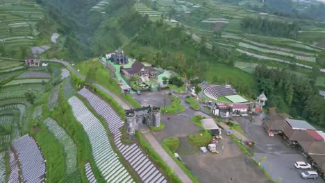 Bird-eye-aerial-view-of-outdoor-park-on-the-hill-in-the-middle-of-agricultural-field-and-valley