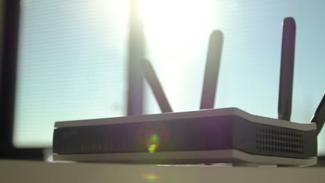 Wunderschöne-Zeitlupe-Eines-WLAN-Routers-Mit-Atemberaubendem-Sonnenlicht-Dahinter,-Nahaufnahme