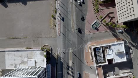 Intersection-in-downtown-Tucson,-Arizona-with-traffic-moving-and-drone-video-overhead-looking-down