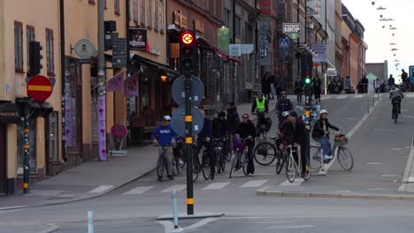 Tráfico-De-Bicicletas-En-Estocolmo-En-Tiempos-De-Corona,-Una-Mujer-Con-Máscara-Pasa-Por-Ahí