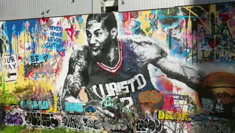 Birds-flying-in-front-of-the-Kobe-Bryant-mural-and-street-art-in-Los-Angeles---Aerial-view