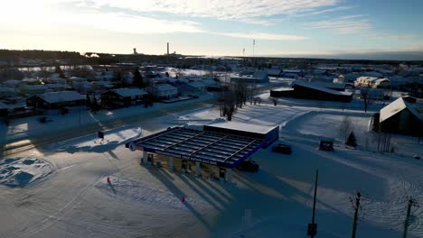 Eine-Dunkle-Schattendrohne-Mit-Weiter-Aufnahme-Der-Tankstelle-Einer-Kleinstadt-Im-NCN-Reservat-In-Thompson,-Manitoba,-Im-Abgelegenen-Norden-Kanadas