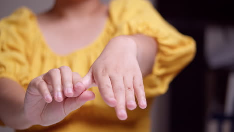 Nahaufnahme-Einer-Frau-Im-Gelben-Hemd,-Die-Sich-Streckt-Und-Dabei-Jeden-Finger-Ihrer-Linken-Hand-Drückt,-Um-Schmerzen-Zu-Lindern