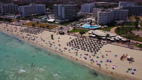 Drone-strafing-over-the-beachfront-of-Cala-Mayor-located-in-Palma-de-Mallorca,-situated-in-the-island-of-Mallorca,-Spain