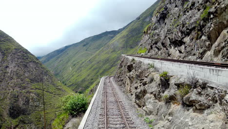 Railway-tracks-curving-around-a-mountain-in-Alausi,-Ecuador,-showcasing-a-scenic-view