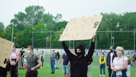 Schlanke-Frau-In-Schwarz,-Die-Bei-Einem-Protest-Ein-Schild-Mit-Dem-Titel-„Black-Lives-Matter“-Hochhält