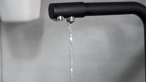 Close-Up-View-of-a-Transparent-Glass-Being-Filled-from-a-Kitchen-Faucet-Dispensing-Filtered-Water