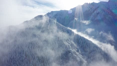 Montañas-Nevadas-De-Bucegi-Alcanzando-Su-Punto-Máximo-A-Través-De-Las-Nubes,-Vista-Aérea