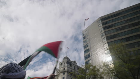 Ein-Arabischer-Mann-In-Einem-Kufiya,-Der-Bei-Einer-Protestkundgebung-Eine-Palästinensische-Flagge-Hoch-In-Die-Luft-Schwenkt