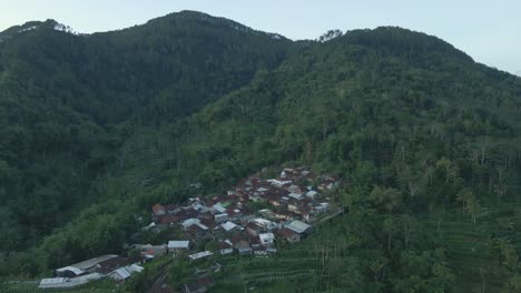 Drone-shot-of-rural-landscape-with-view-of-remote-village-on-forested-hills