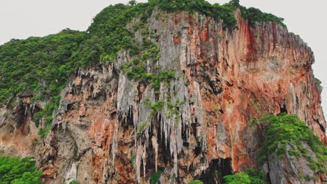 Limestone-Cliff-Face-Pull-Out-Reveal-of-Phra-Nang-Beach-with-an-Aerial-Drone-Tilt-Up-View