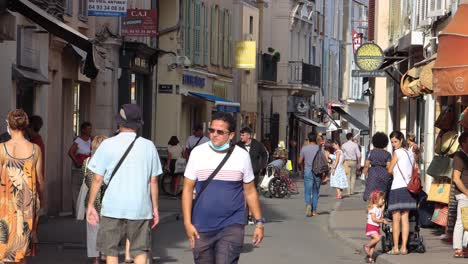 People-walk-and-shop-on-walking-street-in-Antibes-Old-Town,-summer-day