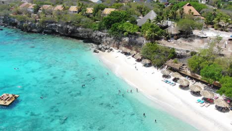 Playa-kalki-in-curacao-with-clear-turquoise-waters-and-beachgoers,-aerial-view