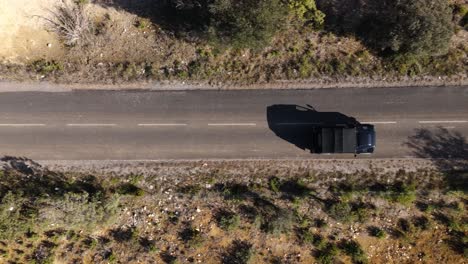 Drone-captures-aerial-tracking-shot-of-a-car-traveling-on-a-scenic-road-in-southern-France