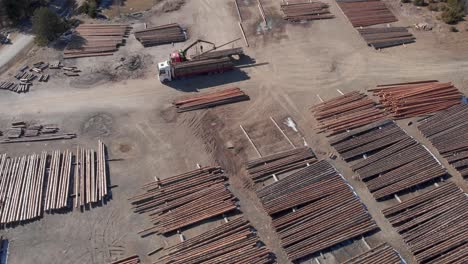 Top-down-Aerial-ascending-Above-Stack-Lumber-Wooden-Logs-Lumberyard