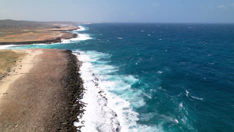 Inclinación-Aérea-Hacia-La-Costa-De-Aruba-Con-Fuertes-Olas