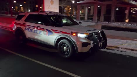 Coches-De-Policía-Circulando-A-Través-De-Cinta-De-Barricada-Amarilla-Por-La-Noche,-Dejando-La-Escena-Del-Crimen-En-Vaughan,-Ontario,-Canadá