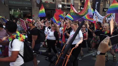 Close-view-of-people-walking-and-dancing-with-rainbow-flags-in-the-Pride-Parade-in-Stockholm