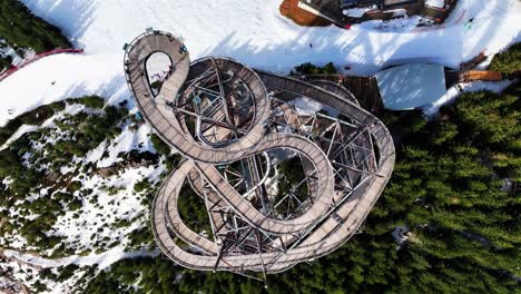 Top-down-aerial-ascend-over-sky-walk-tower-attraction,-Dolni-Morava-Czechia