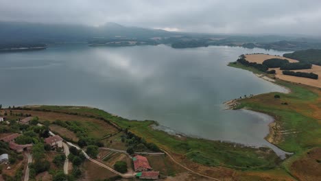 Lago-Nanclares-De-Gamboa-En-El-País-Vasco,-España,-Con-Cielo-Nublado,-Vista-Aérea