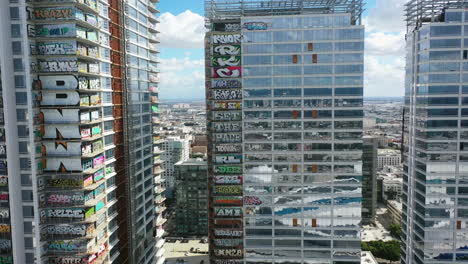 Aerial-view-flying-toward-the-Graffiti-tower-buildings,-in-downtown-Los-Angeles