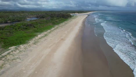 Schaumige-Wellen-Plätschern-Am-Sandstrand-Von-Ownil-Beach,-Byron-Bay,-NSW,-Australien-–-Drohnenaufnahme