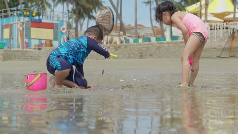 Two-Asian-children-playing-on-the-sand-at-a-beautiful-beach