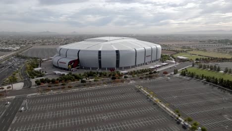 State-Farm-Stadium,-home-of-the-Arizona-Cardinals-National-Football-League-team-in-Glendale,-Arizona-with-empty-parking-lot-drone-video-moving-in