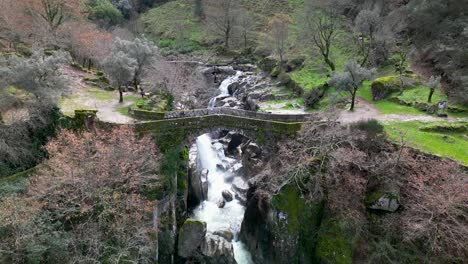 Orbit-Aufnahme-über-Malerische-Mittelalterliche-Steinbrücke,-Mizarela-Braut,-Umgeben-Von-Grüner-Landschaft,-Portugal