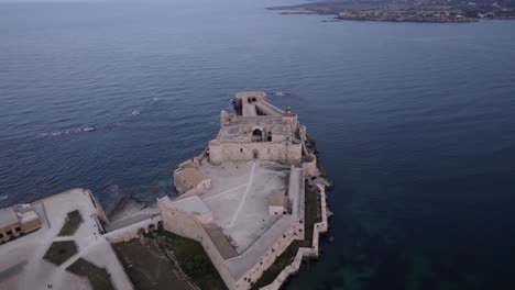 Aerial-Maniace-Castle,-a-fortified-monument-on-Ortigia-island,-Italy