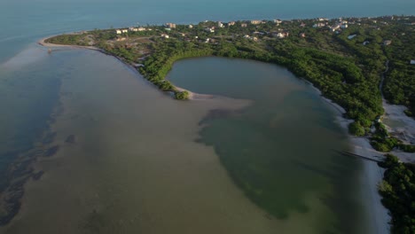 Holbox-island's-lush-landscape-and-tranquil-waters-at-golden-hour,-aerial-view