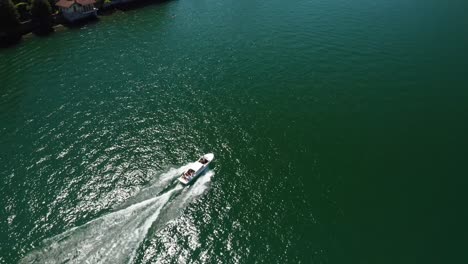 Speedboat-cruising-on-Lake-Como-with-lush-surroundings,-aerial-view