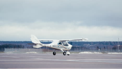 Aviones-Ultraligeros-Rodando-A-Través-De-Disparos-Estáticos-En-El-Asfalto-De-La-Plataforma-Del-Aeródromo-Con-Nieve-Visible-En-El-Fondo