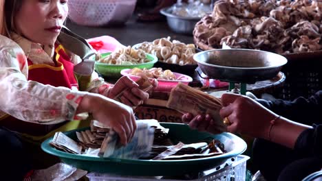 Las-Personas-Solo-Usan-Sus-Manos-Para-Contar-La-Moneda-Laosiana,-Conocida-Como-Kip-O-Lak,-Y-La-Colocan-En-Un-Recipiente-De-Plástico-En-Un-Ambiente-Animado.