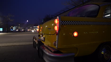 Langsam-Nähernde-Checker-Taxi-Heckscheinwerfer-Beleuchtet-Roten-Schein-In-Der-Nacht