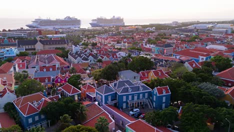 Stunning-historic-multicolored-buildings-of-Kura-Hulanda-village-in-Otrobanda-Willemstad-Curacao-with-cruise-ships-docked-in-distance
