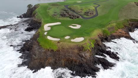 Pebble-beach-golf-links-with-rugged-coastline-and-crashing-waves,-aerial-view