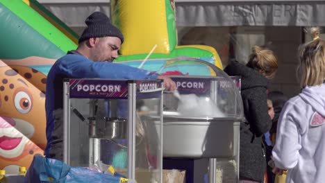 A-vendor-prepares-cotton-candy-for-a-customer-at-the-Gnoccolada-carnival-festival-in-Brixen---Bressanone,-South-Tyrol,-Italy