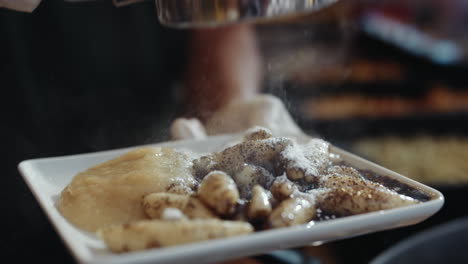 Serving-potato-noodles-with-poppy-seeds,-applesauce-and-sugar