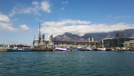 Puerto-Industrial-En-Ciudad-Del-Cabo-Y-Montañas-De-Fondo-Vistas-Desde-Un-Barco-En-Movimiento