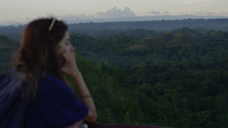 Out-of-focus-young-woman-contemplating-Bohol-chocolate-hills-in-the-jungle